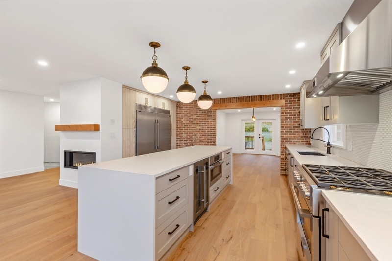 white kitchen with hardwood floor and fireplace